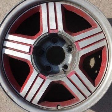 Car wheel with silver and red accents, five-spoke design.
