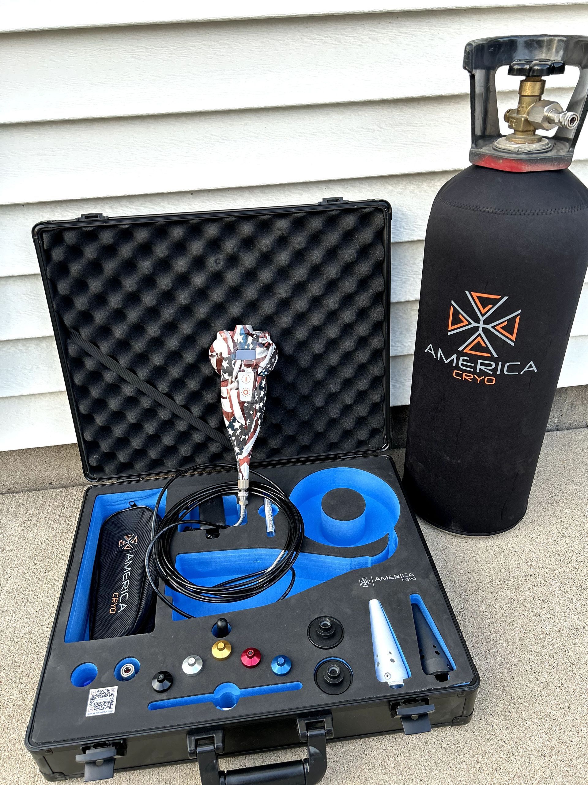 Hookah kit in a foam-lined case beside a black gas cylinder outdoors.