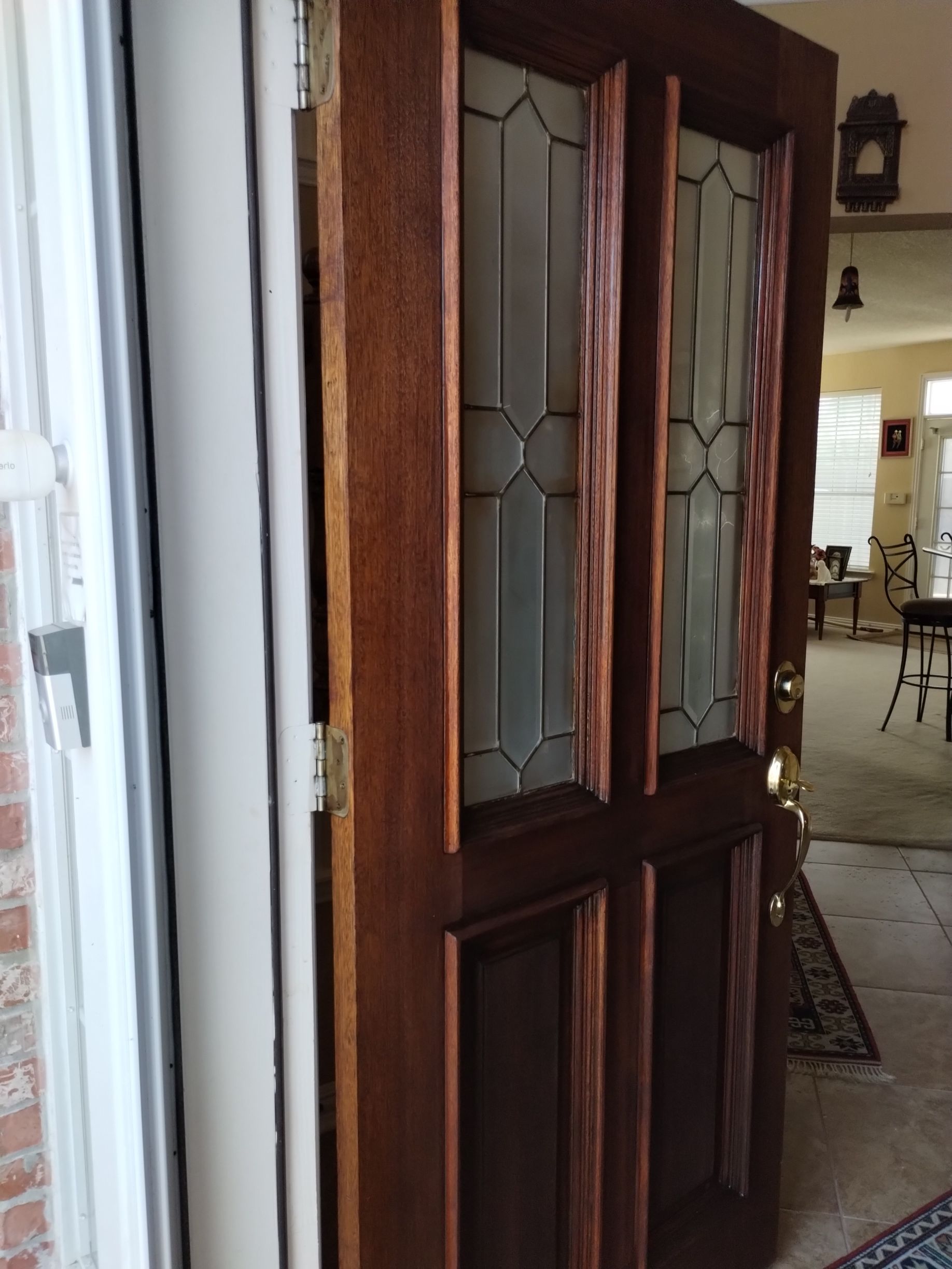 Open wooden door with glass panels, partially revealing a hallway.