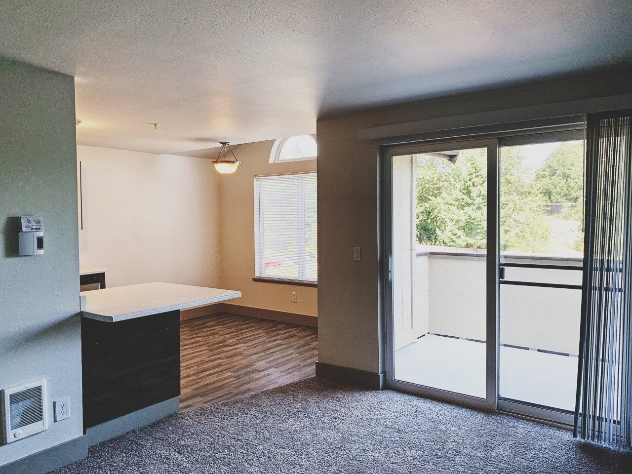 A living room with a sliding glass door leading to a balcony.