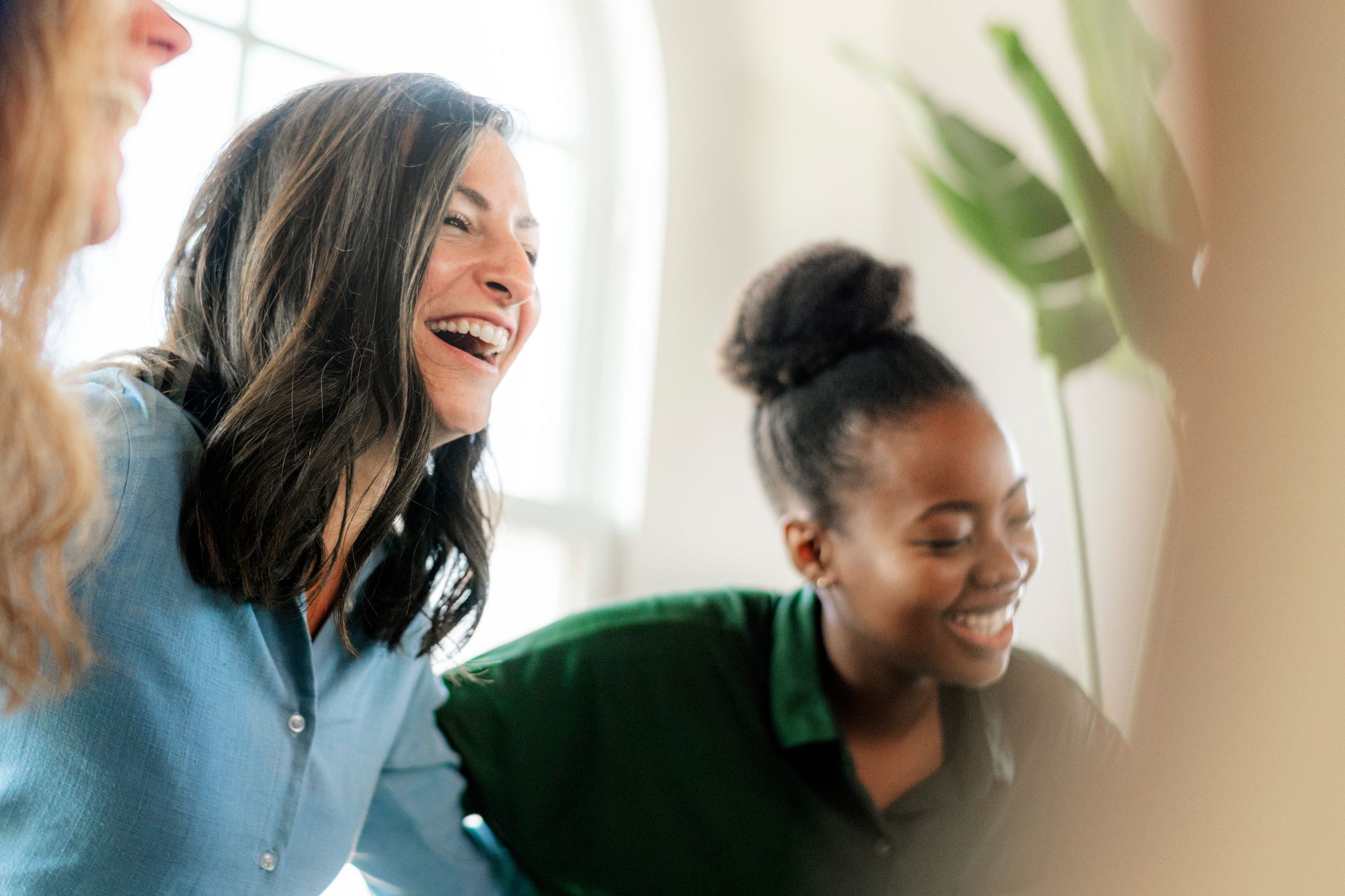 Two people smiling and laughing in a bright office setting