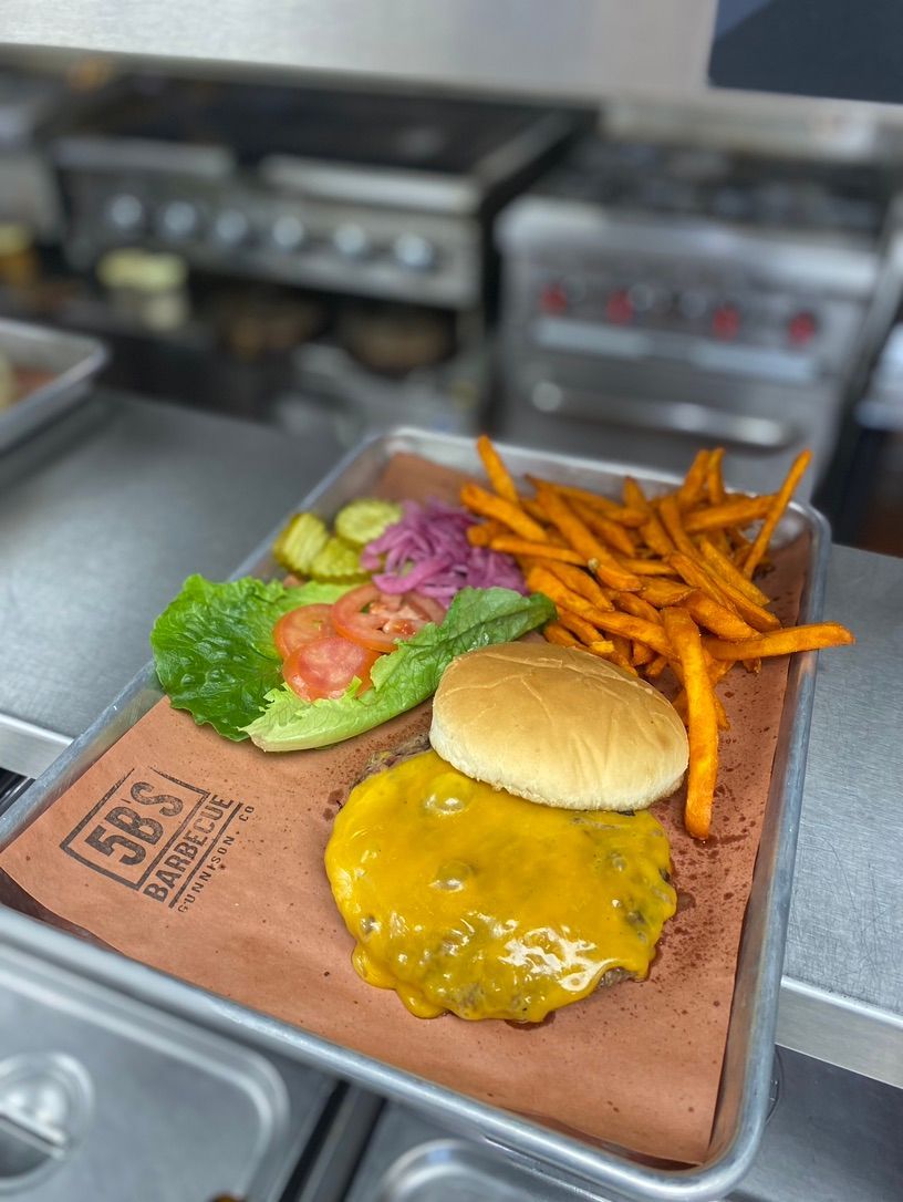 A hamburger and french fries on a tray on a counter