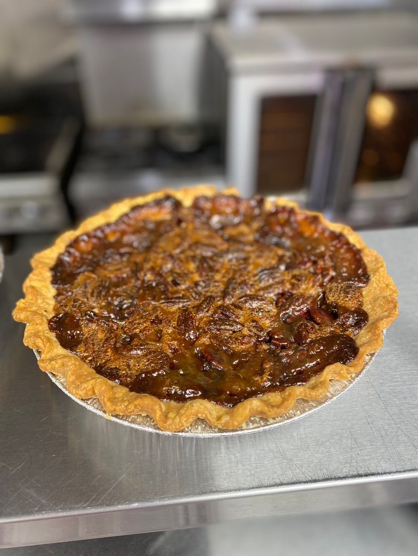 A pecan pie is sitting on top of a metal table.