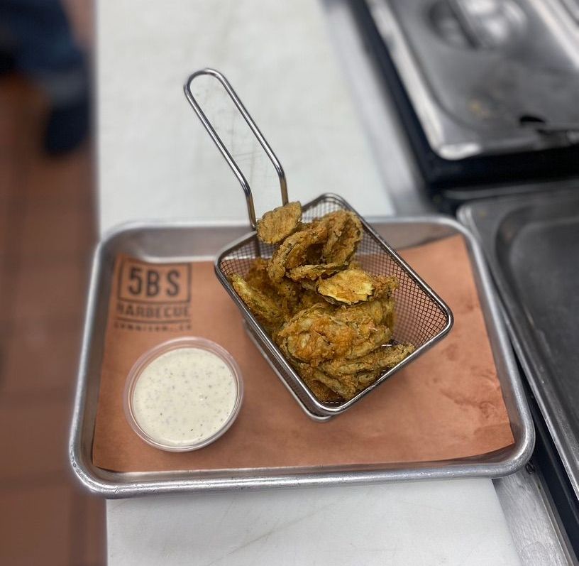A basket of fried pickles with ranch dressing on a tray from 5bs barbecue