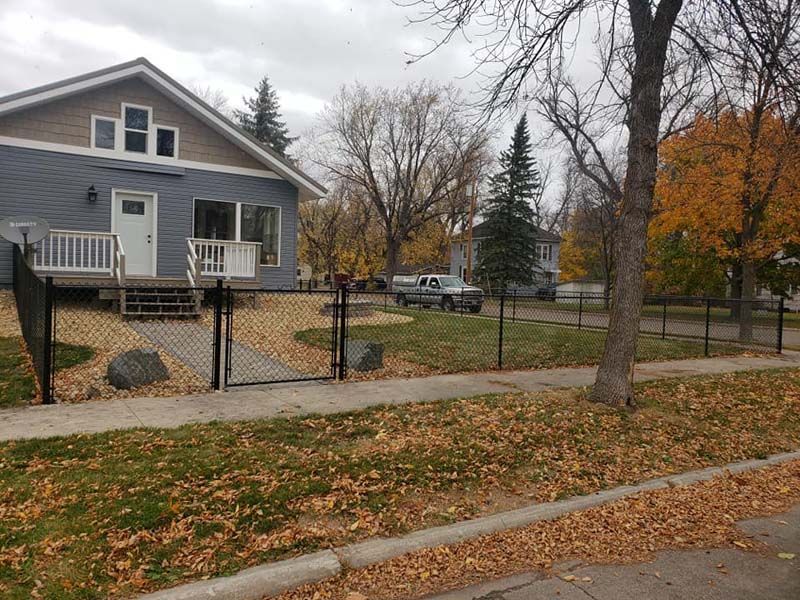 A house with a chain link fence in front of it