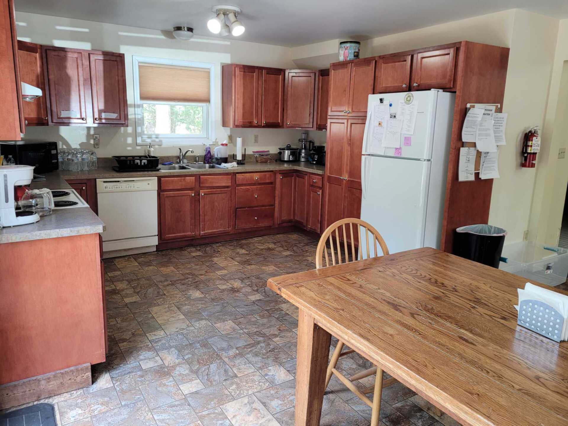 A kitchen with a table and chairs and a refrigerator