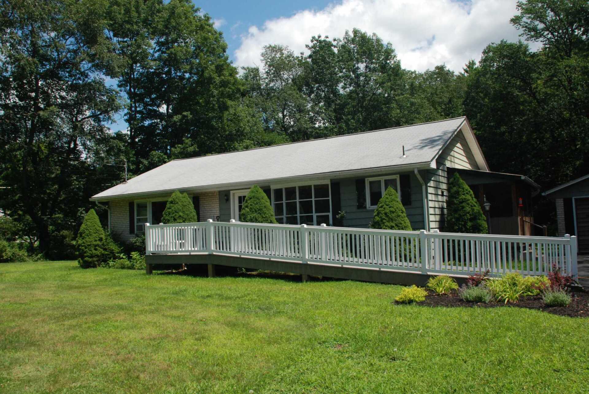 A house with a white fence and a ramp in front of it