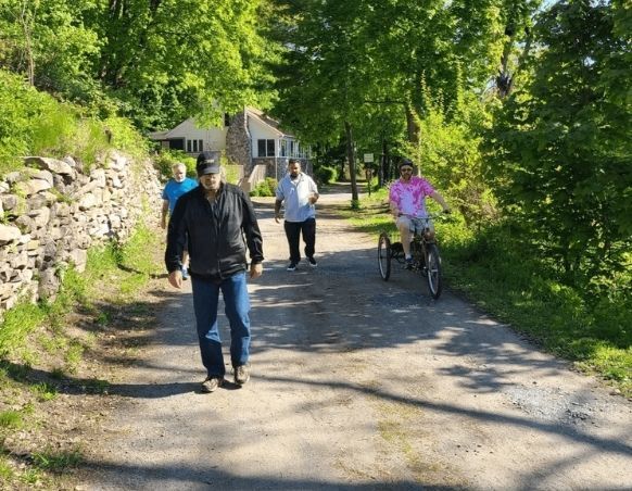 A group of people are walking down a dirt road.