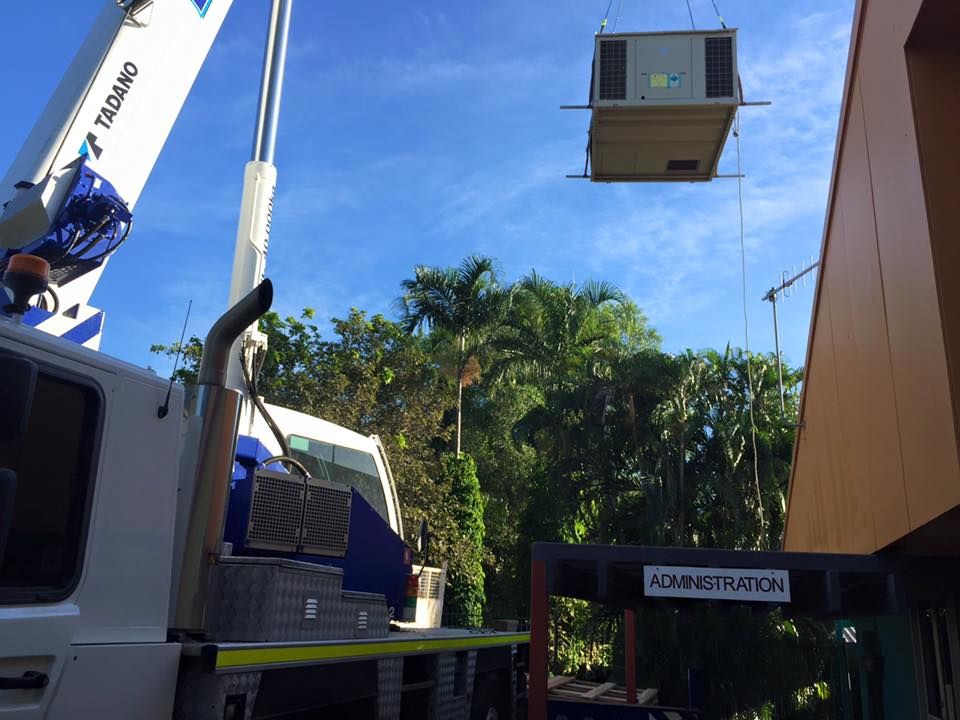 A Truck Is Lifting An Air Conditioner With A Crane— The Cool Guys In Holtze, NT