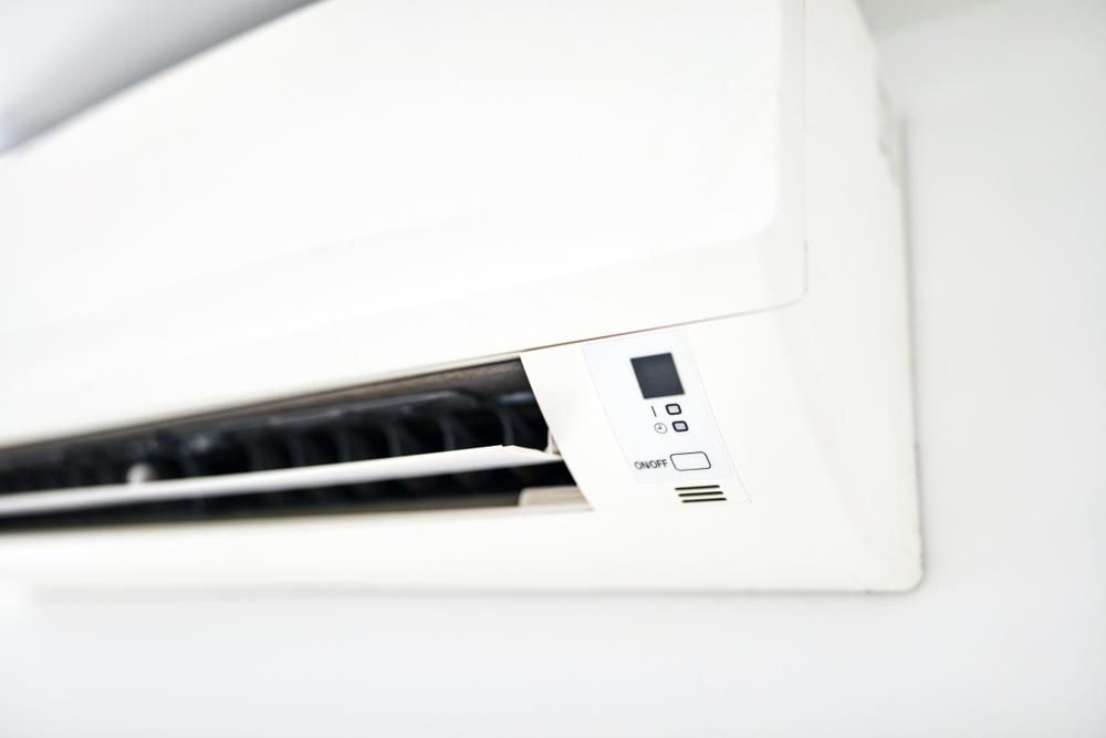A White Air Conditioner is Hanging on a White Wall — The Cool Guys In Humpty Doo, NT