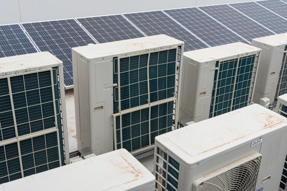 A Row of Air Conditioners and Solar Panels on the Roof of a Building — The Cool Guys In Holtze, NT