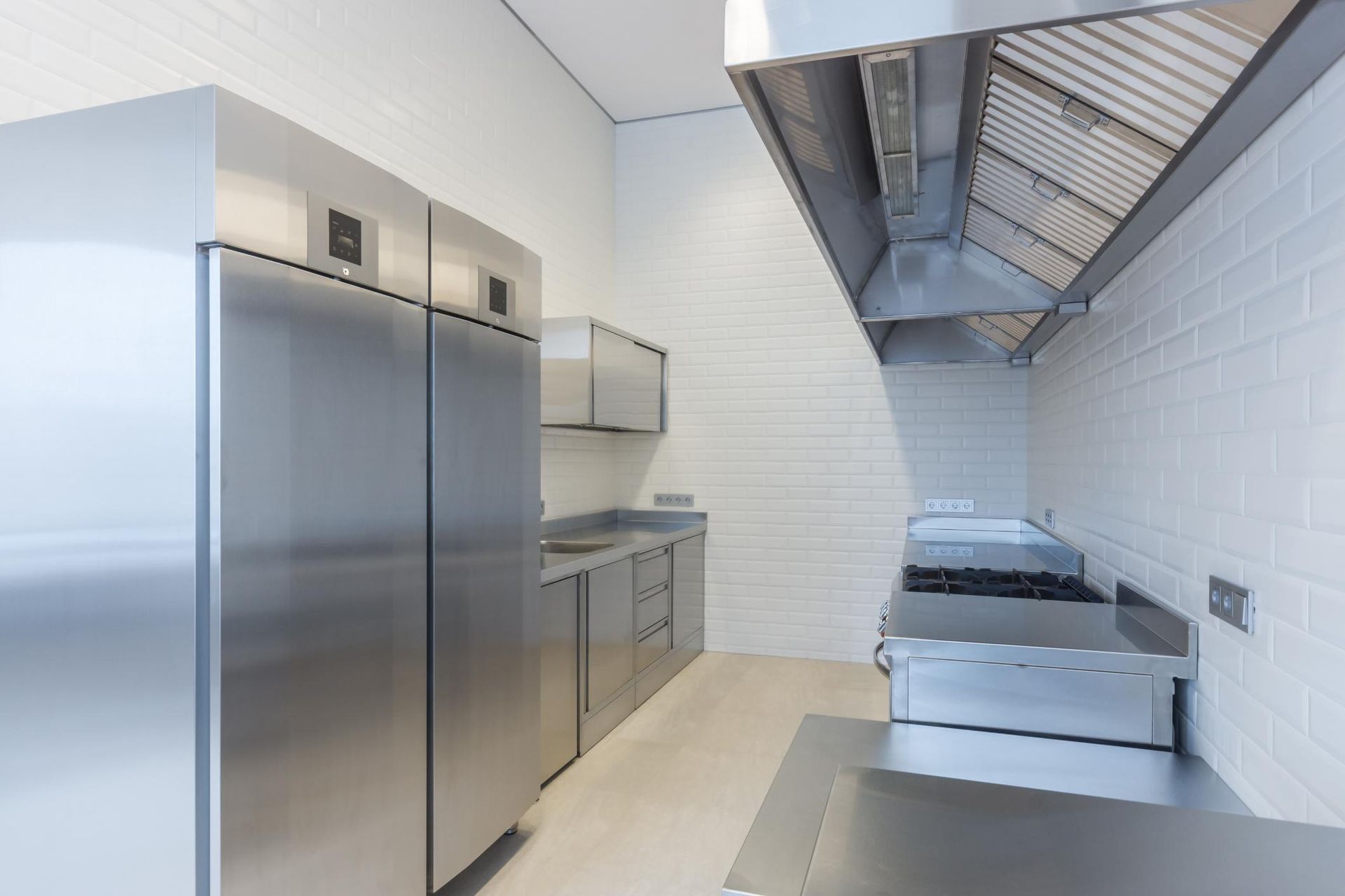 A Kitchen With Stainless Steel Appliances and White Tiles — The Cool Guys In Holtze, NT