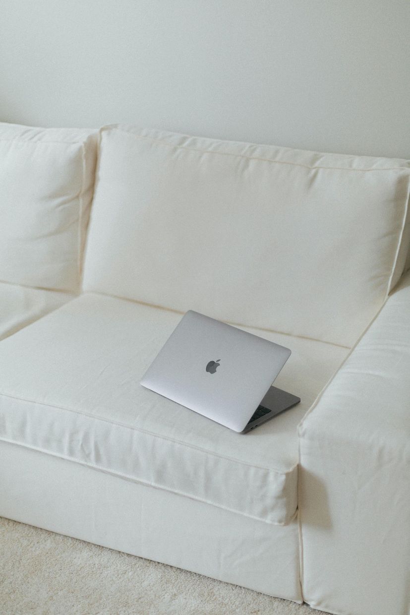 Silver laptop on a white sofa in a bright minimalist living room