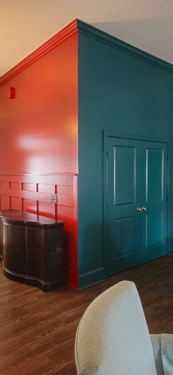 A hallway with columns and a ladder in it is being painted.