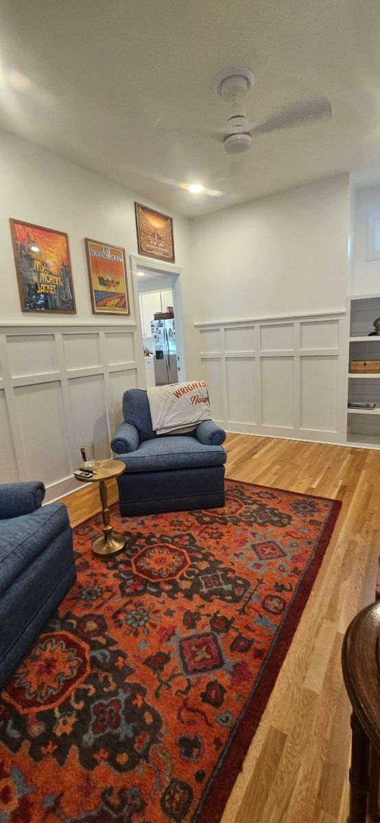A living room with a white ceiling and paintings on the walls