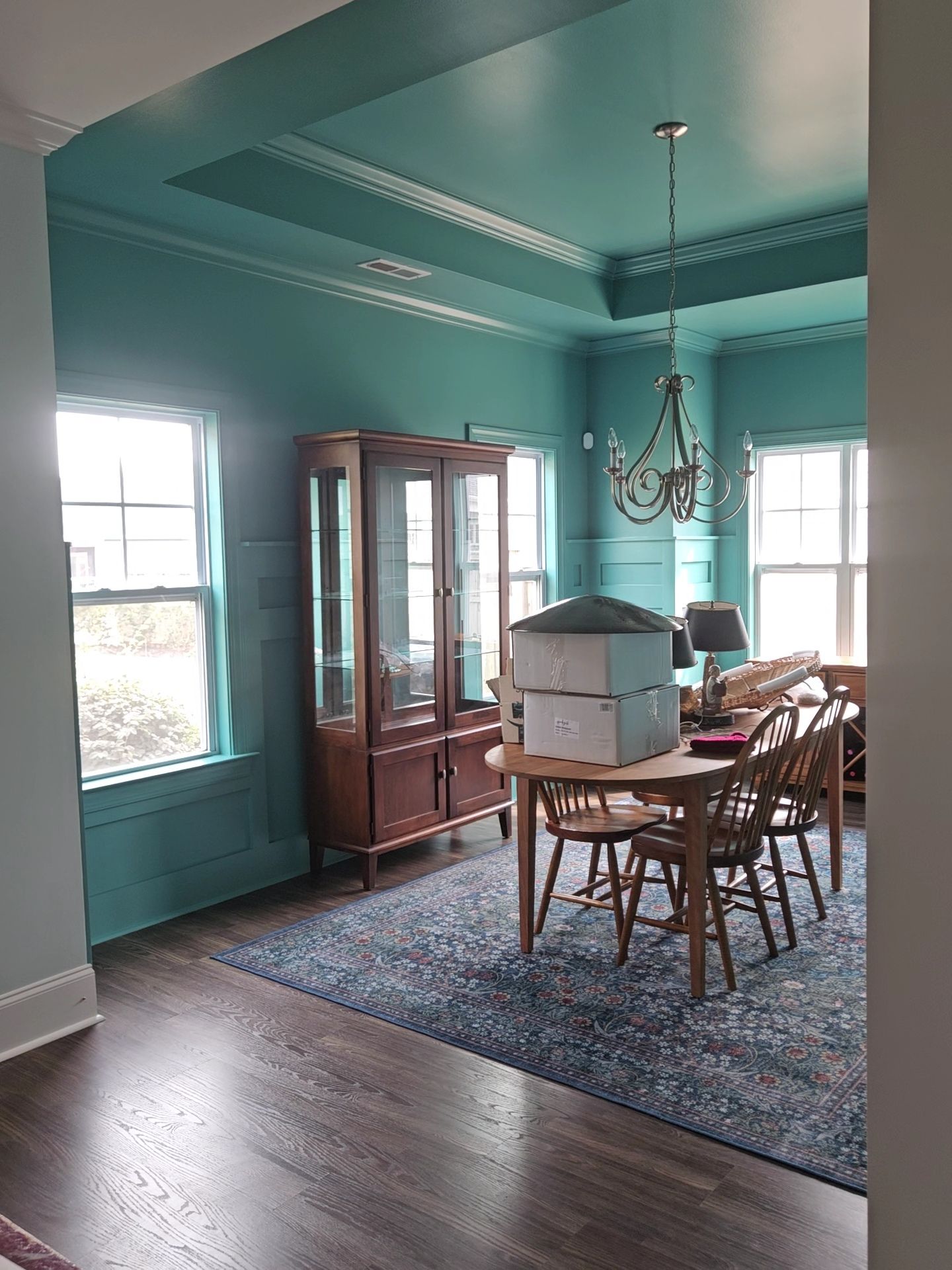 A kitchen with white cabinets and a stove top oven being painted.