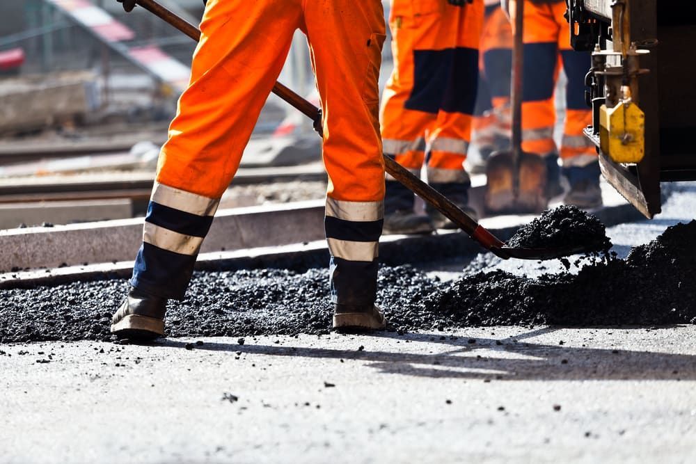A Group Of Construction Workers Are Working On A Road — Andrew Johnston Haulage In Ballina, NSW