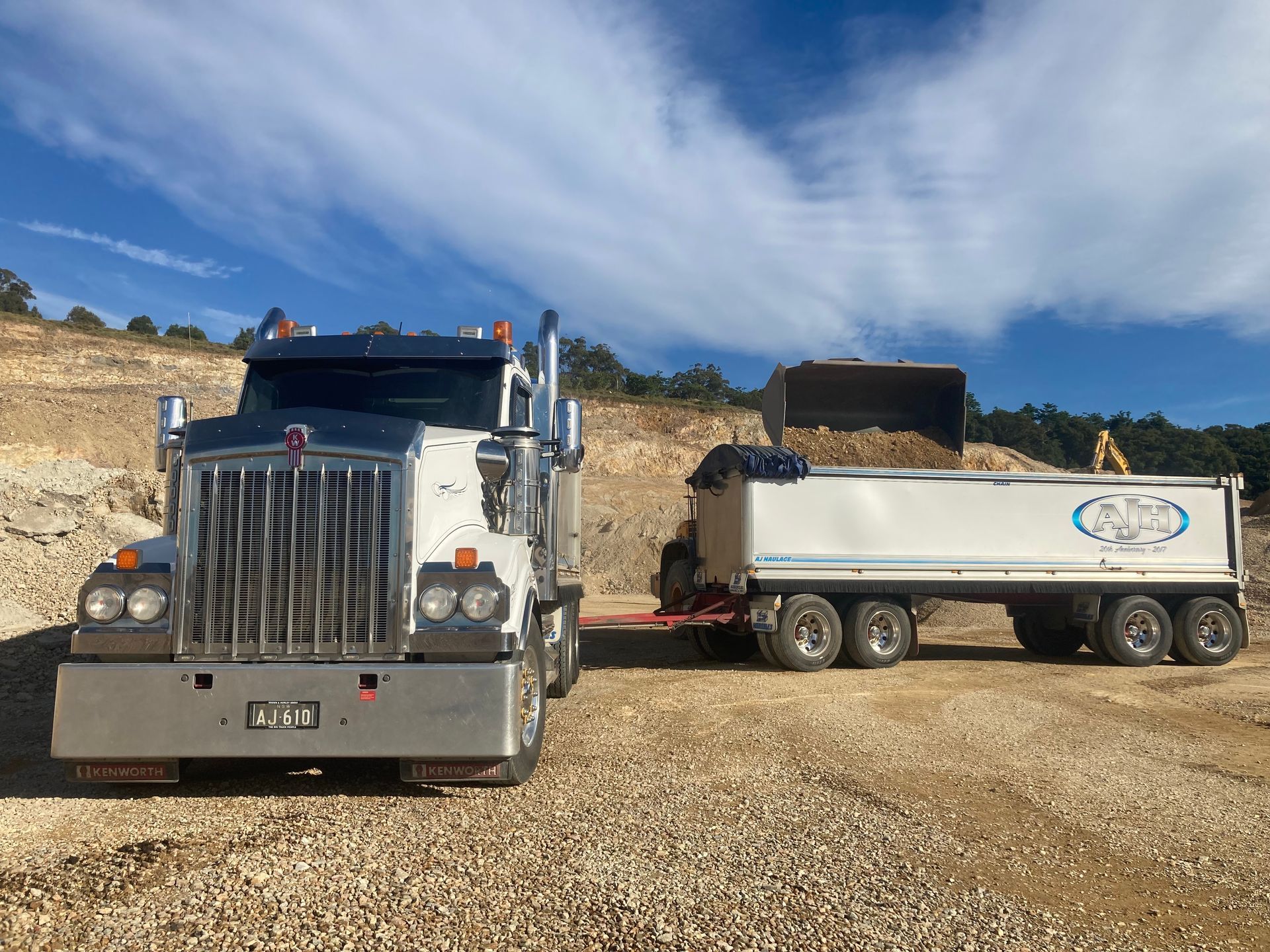 A Dump Truck and Trailer Are Parked in a Gravel Lot — Andrew Johnston Haulage In Ewingsdale, NSW