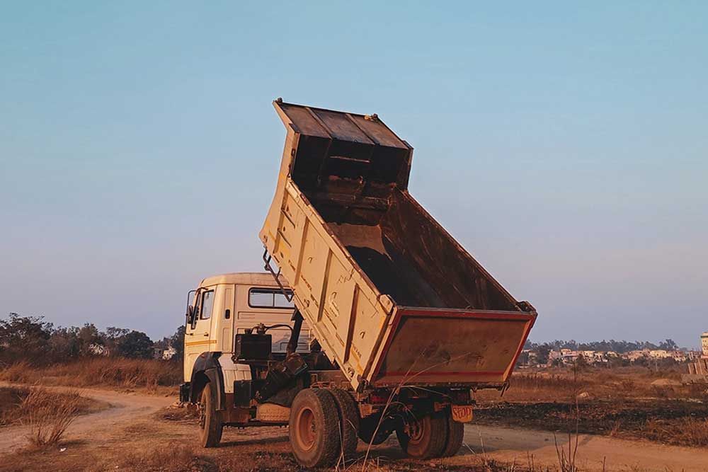 A Dump Truck Is Parked On The Side Of A Dirt Road — Andrew Johnston Haulage In Byron Bay, NSW