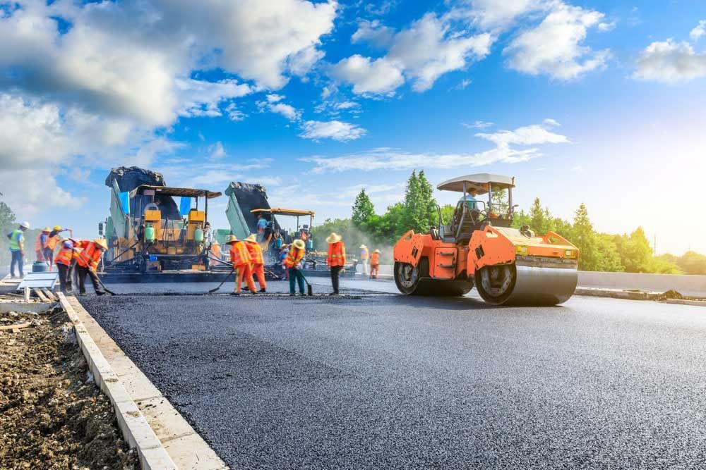 A Group Of Construction Workers Are Working On A Road — Andrew Johnston Haulage In Lismore, NSW