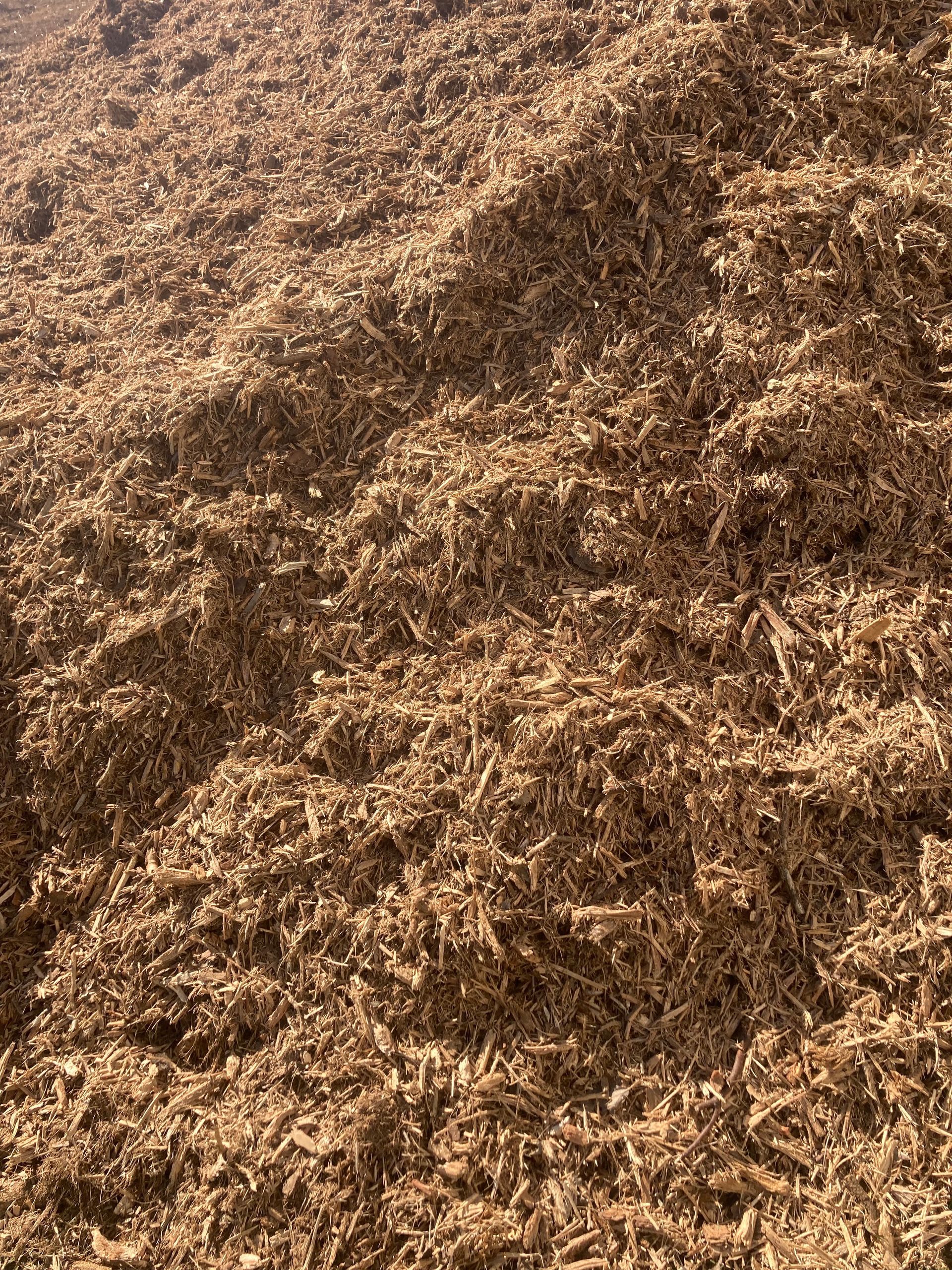 A Pile of Brown Wood Chips is Sitting on the Ground — Andrew Johnston Haulage In Ewingsdale, NSW