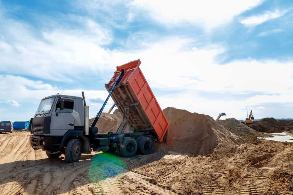 A Dump Truck Is Loaded With Sand At A Construction Site — Andrew Johnston Haulage In Ballina, NSW