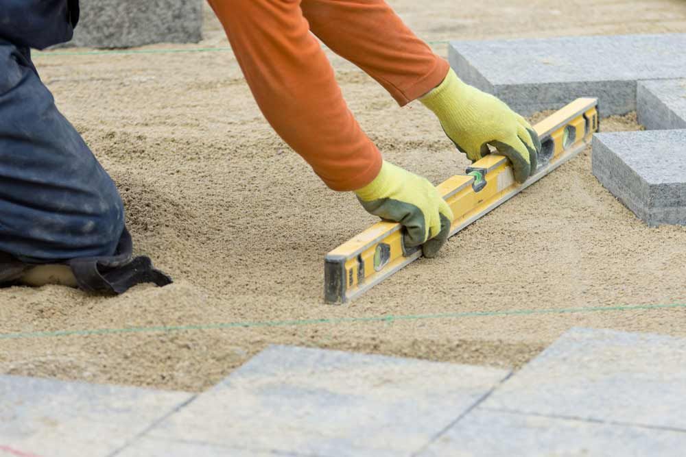 A Person Is Using A Yellow Level To Level The Ground — Andrew Johnston Haulage In Gold Coast, QLD