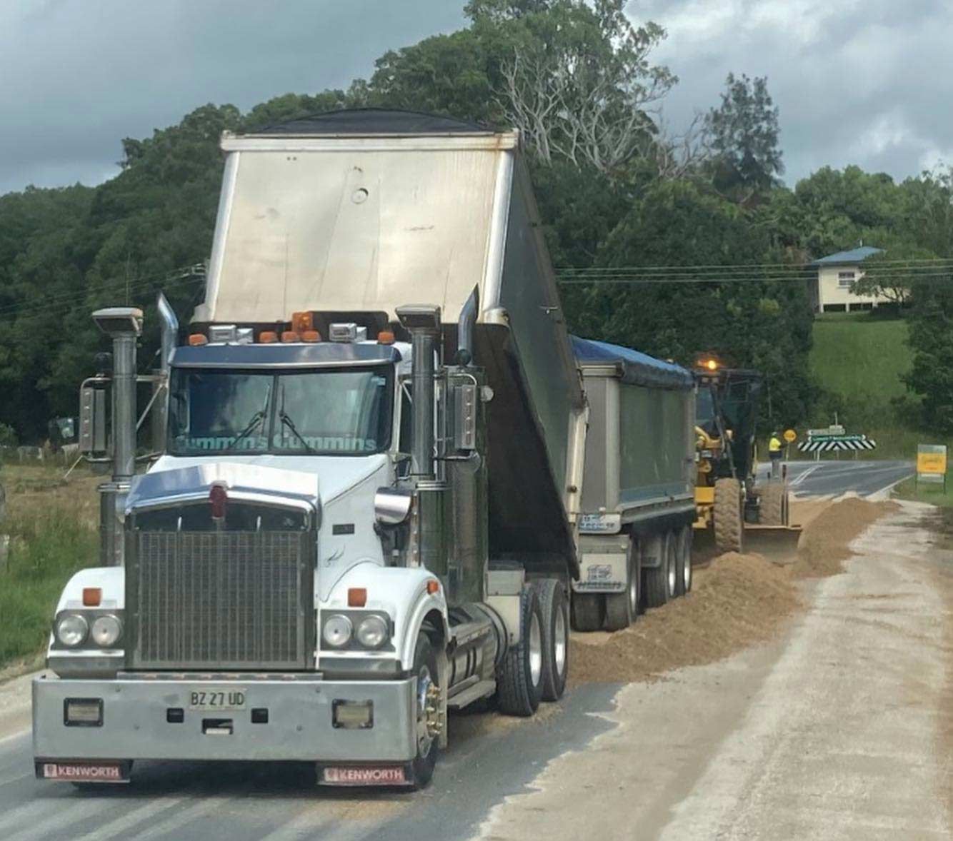 A Kenworth Dump Truck is Driving Down a Dirt Road — Andrew Johnston Haulage In Ewingsdale, NSW