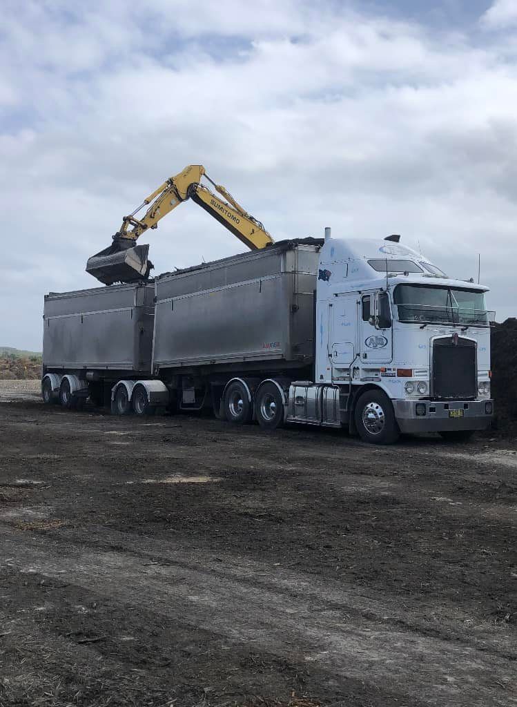 A Kenworth Semi Truck Is Being Loaded With Dirt — Andrew Johnston Haulage In Ewingsdale, NSW