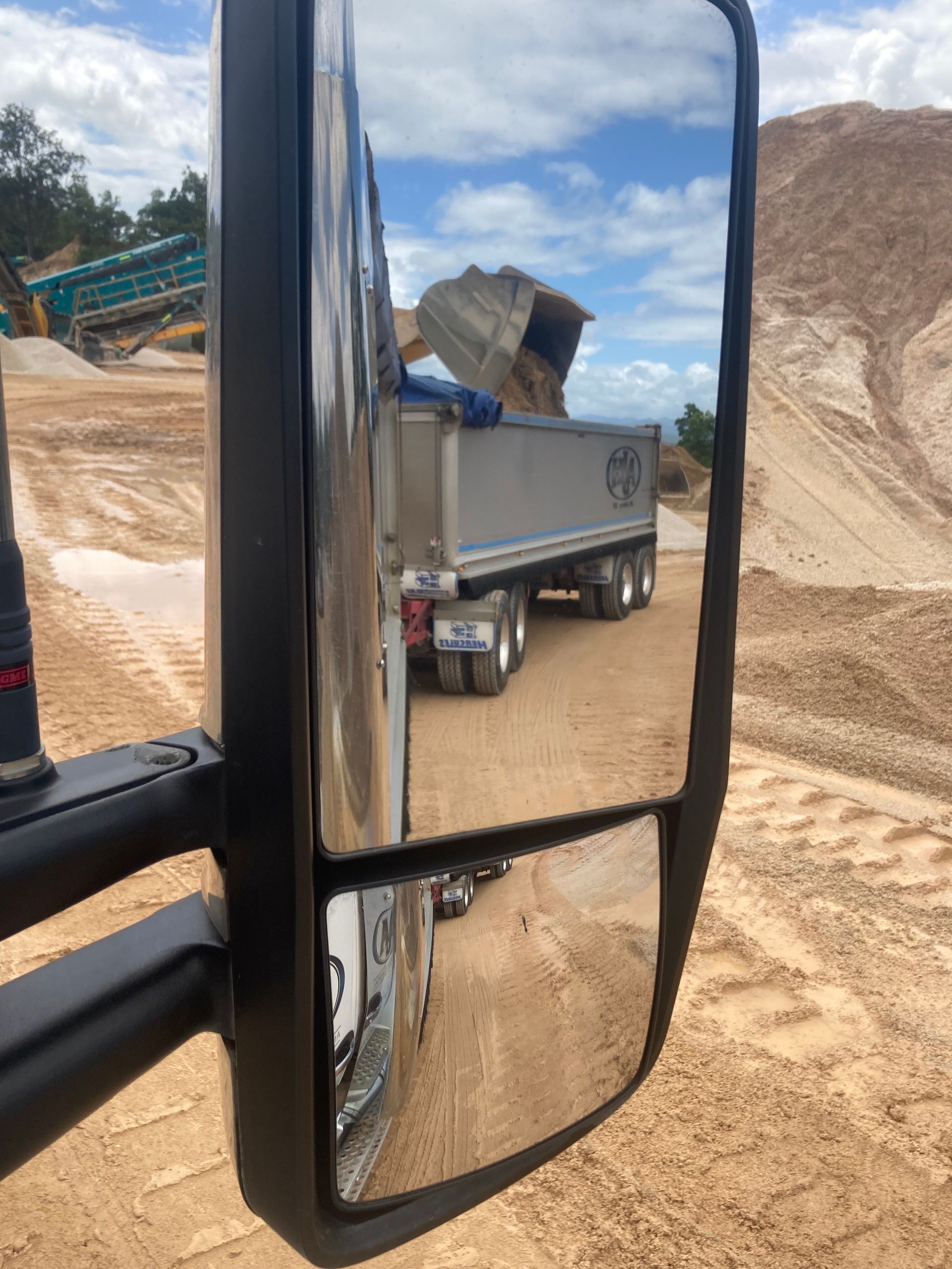 A Dump Truck is Reflected in the Side View Mirror of a Truck — Andrew Johnston Haulage In Ewingsdale, NSW