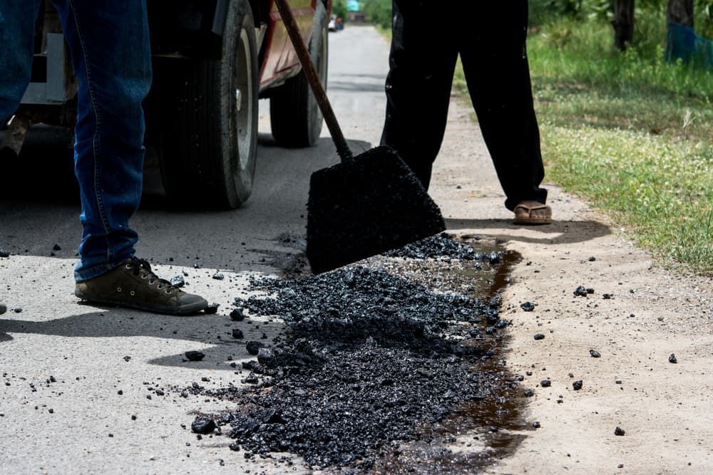 A Person Is Using A Shovel To Dig A Hole In The Road— Andrew Johnston Haulage In Tweed Heads, NSW