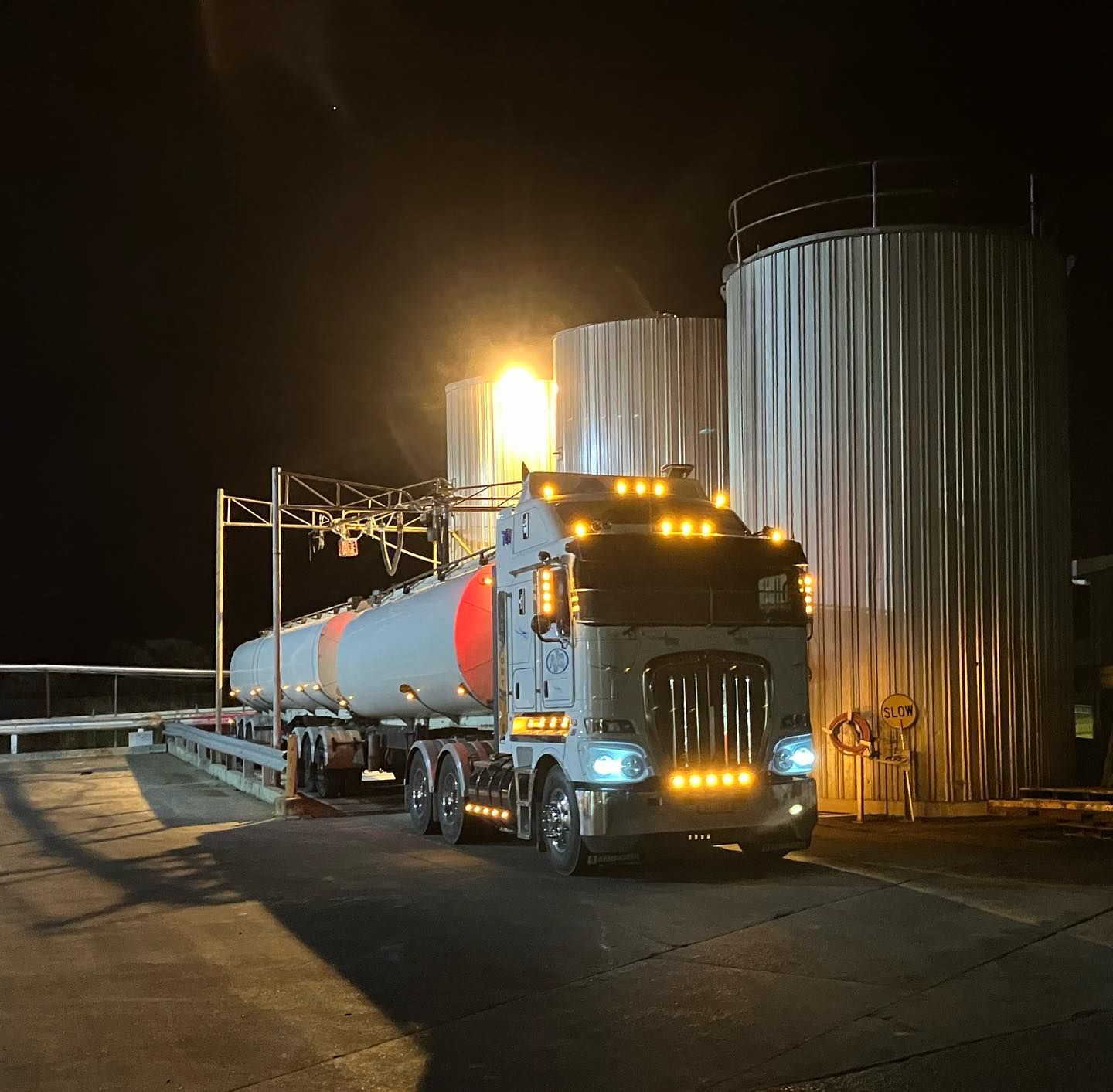 A Tanker Truck Is Parked In Front Of A Silo At Night — Andrew Johnston Haulage In Ballina, NSW
