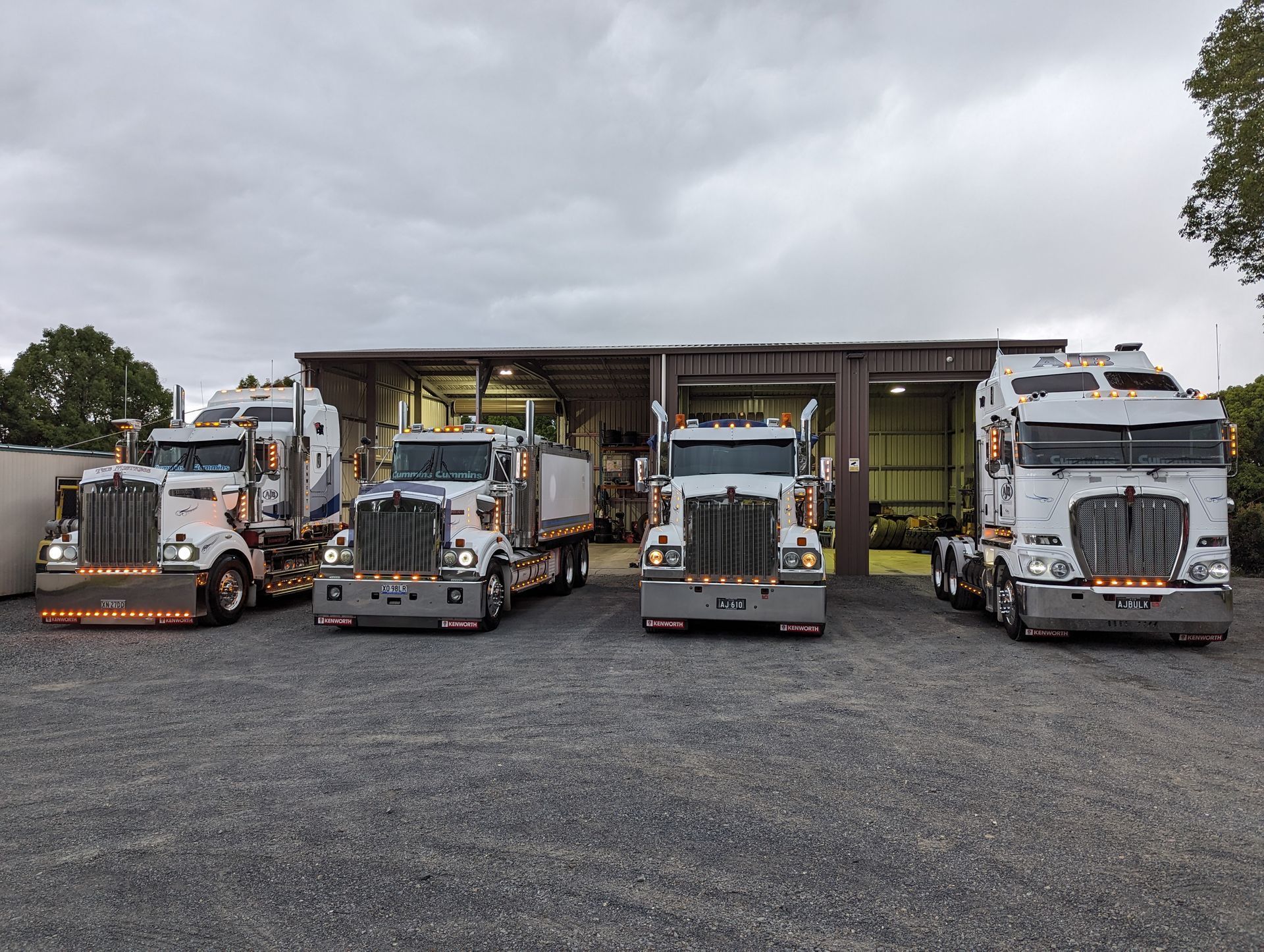 A Row of Semi Trucks Parked in Front of a Building — Andrew Johnston Haulage In Ewingsdale, NSW