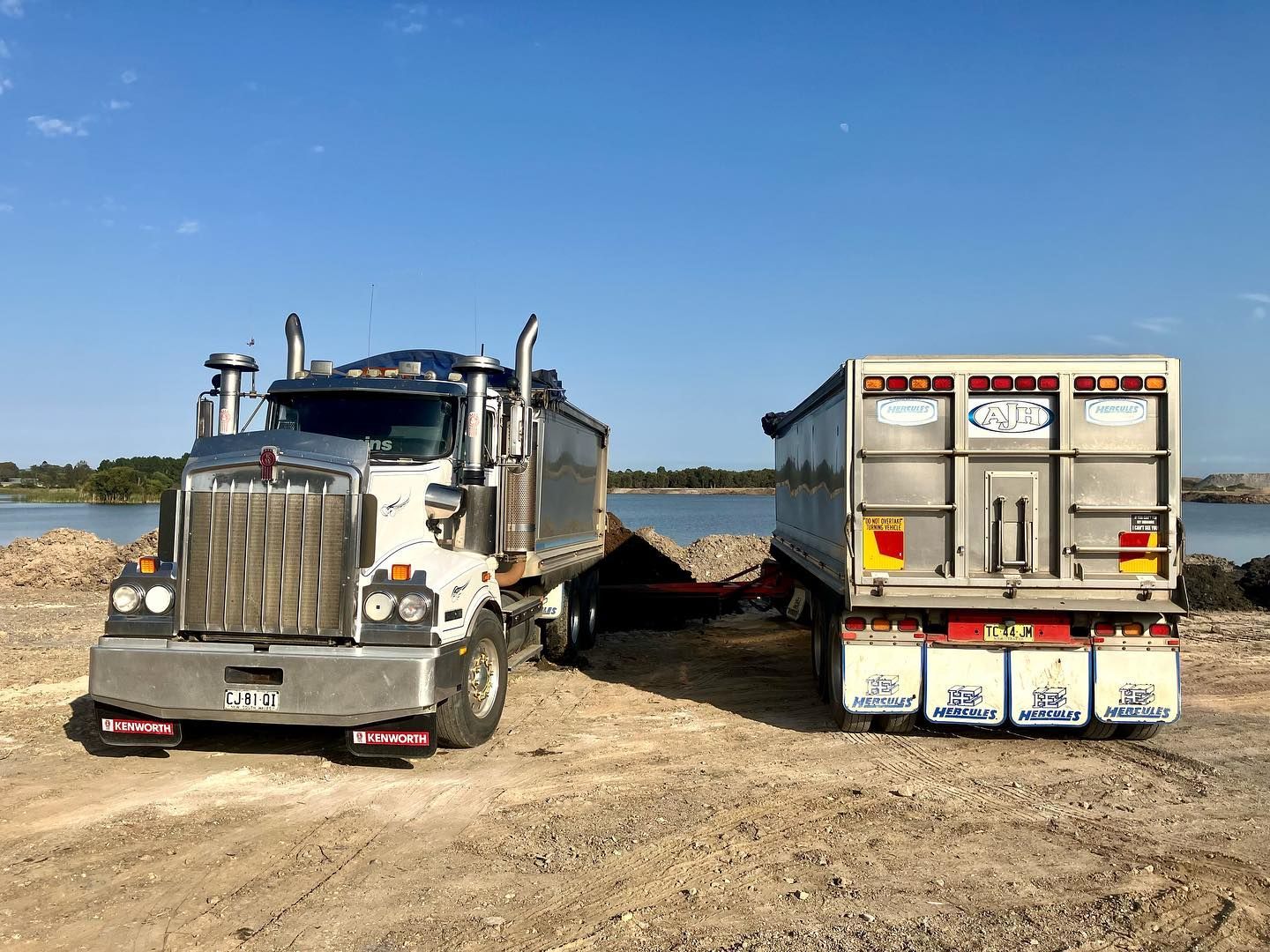 Two Dump Trucks Are Parked Next to Each Other in a Dirt Field — Andrew Johnston Haulage In Lismore, NSW