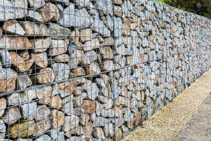 A Stone Wall With A Metal Fence Surrounding It — Andrew Johnston Haulage In Ewingsdale, NSW