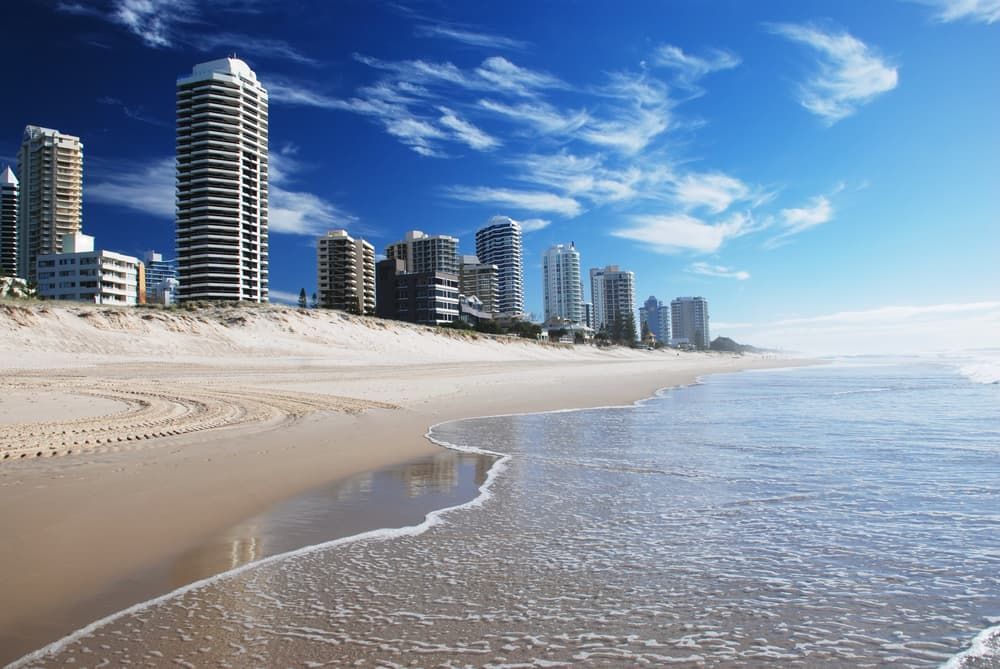 A Beach With Tall Buildings in the Background and a City in the Distance — Andrew Johnston Haulage In Gold Coast, QLD