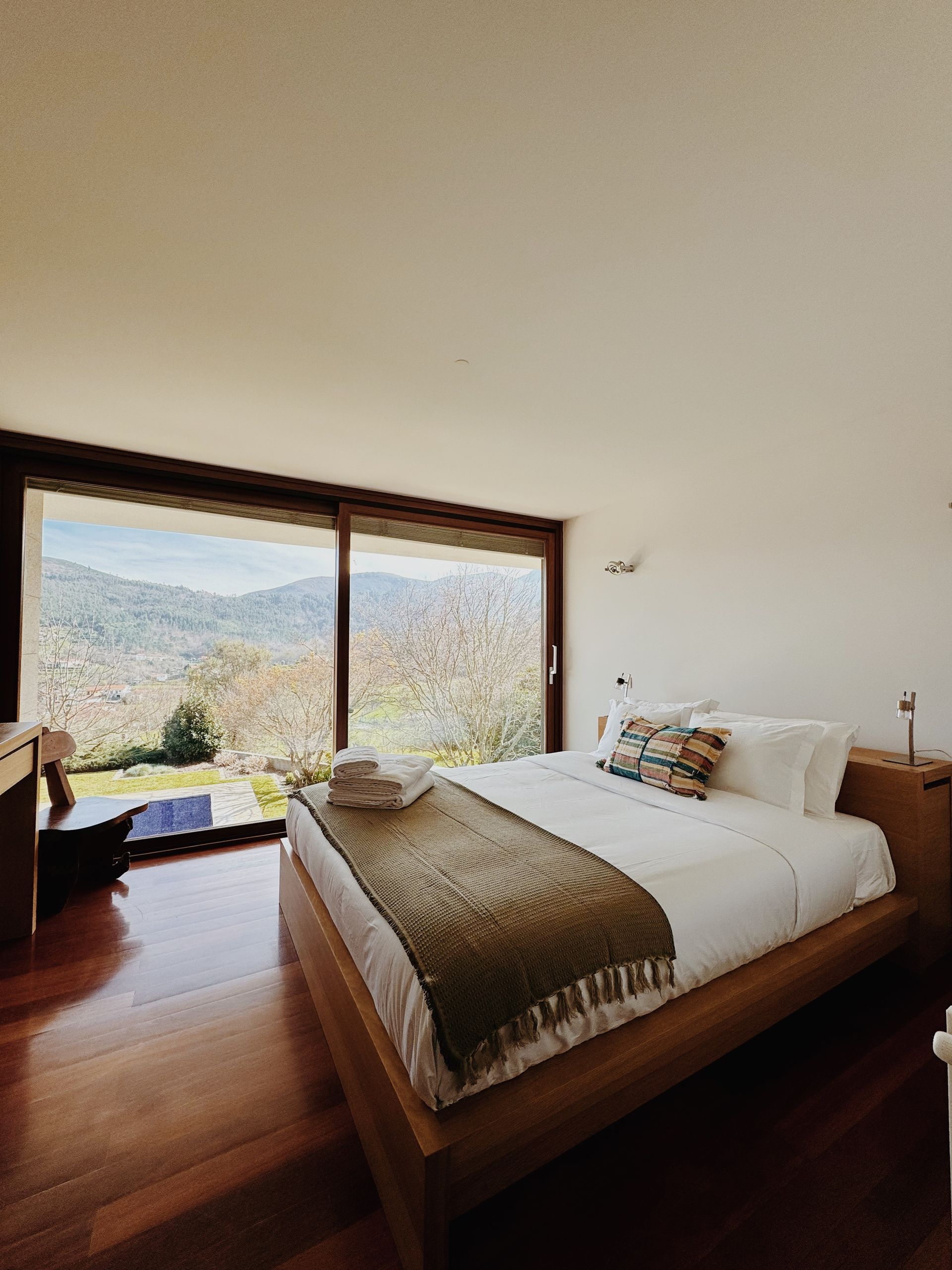 Um quarto com uma cama grande e uma janela grande