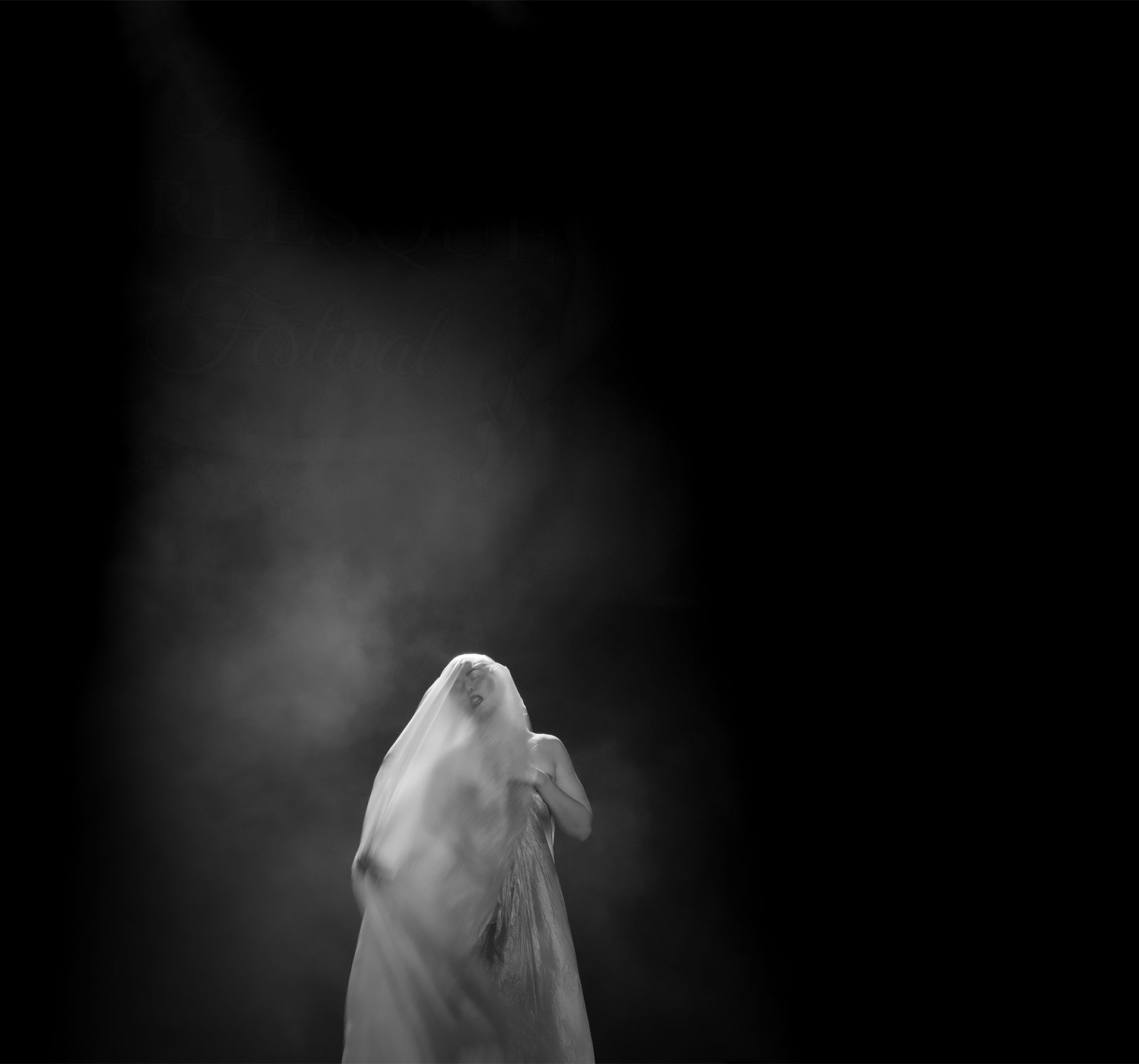 Une silhouette drapée de tissu blanc se détachant sur un fond noir, partiellement masquée par la fumée.