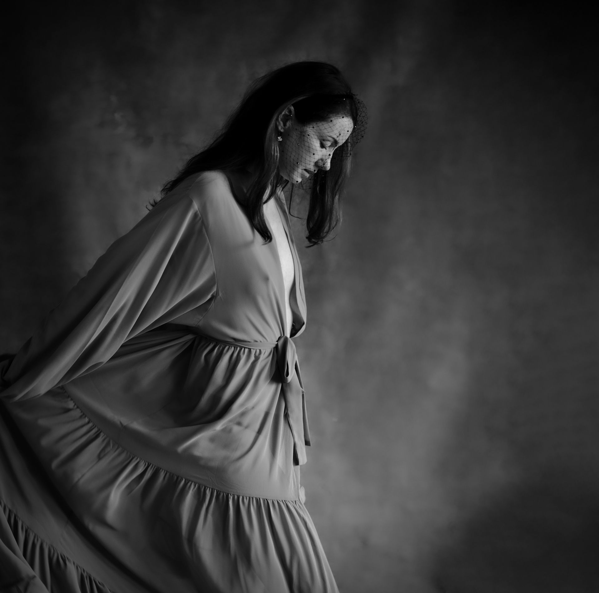 Femme en robe fluide, tête baissée, tissu en mouvement, portrait en studio, Savièse, Valais