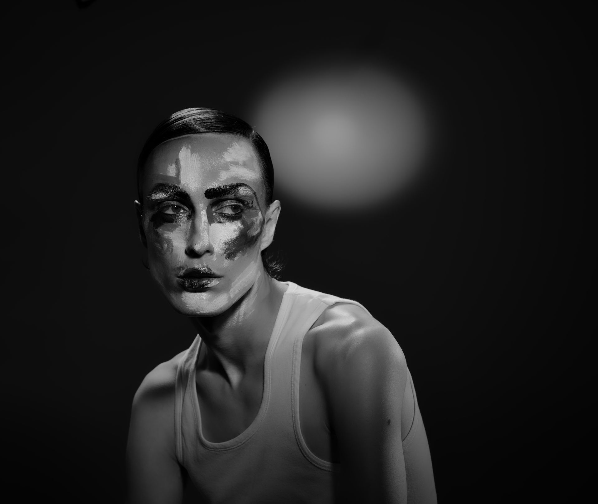 Une femme en robe à volants, tenant une épée, est assise sur une boîte noire.