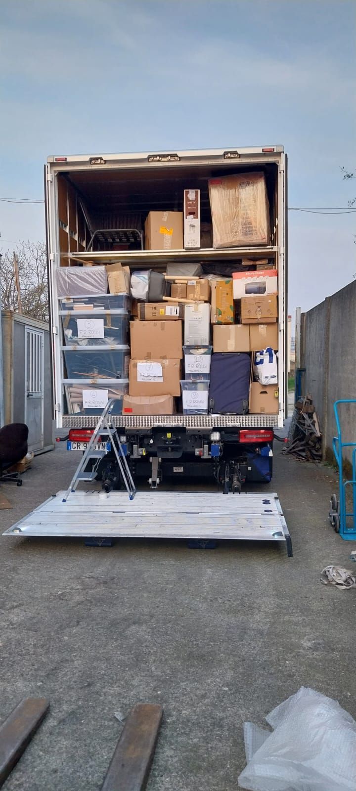 Container aperto per camion, carico di scatole di cartone e merci, presso una banchina di carico.