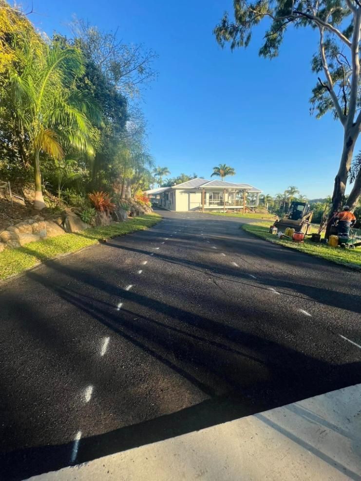 A House Is Sitting On The Side Of A Road Next To A Tree — Elite Bitumen & Asphalt In Airlie Beach, QLD