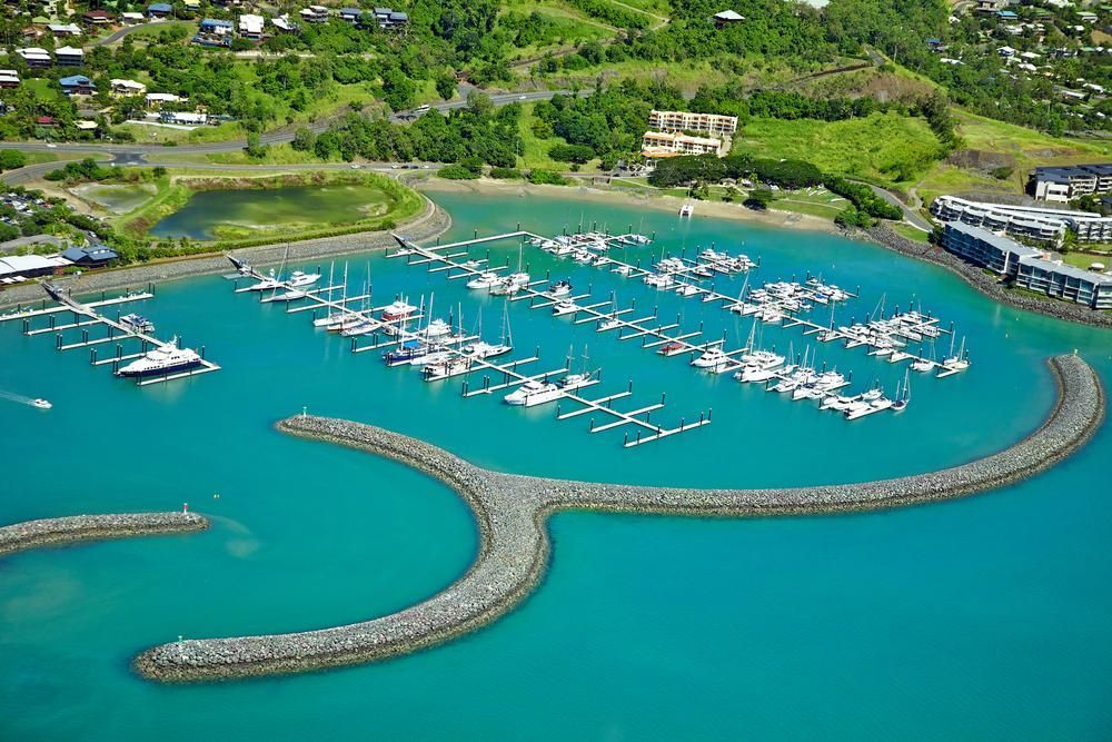 An Aerial View Of A Marina With Boats Docked In The Water — Elite Bitumen & Asphalt In Airlie Beach, QLD