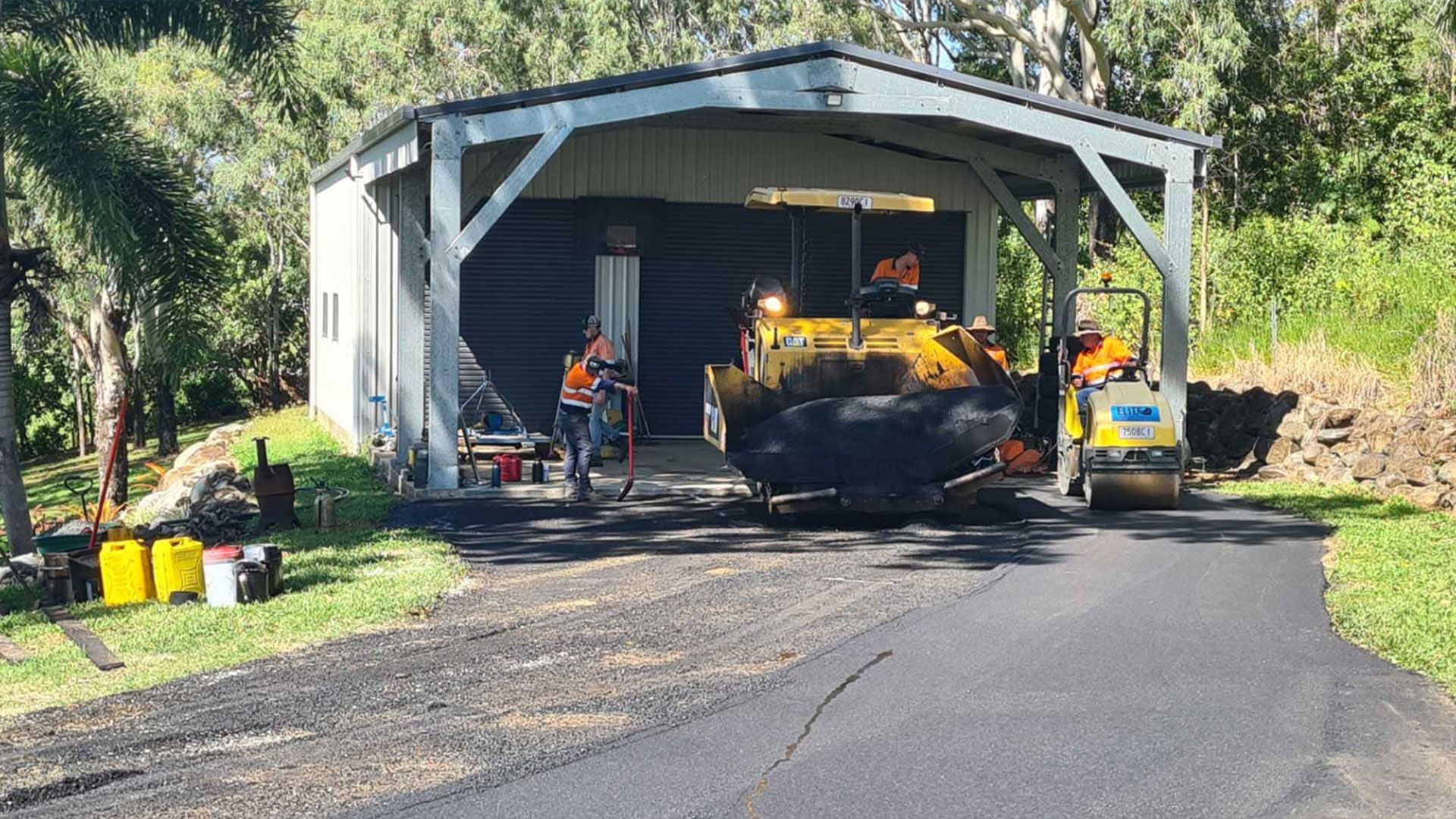 Two Men Are Working On A Bitumen Driveway — Elite Bitumen & Asphalt In Mackay, QLD