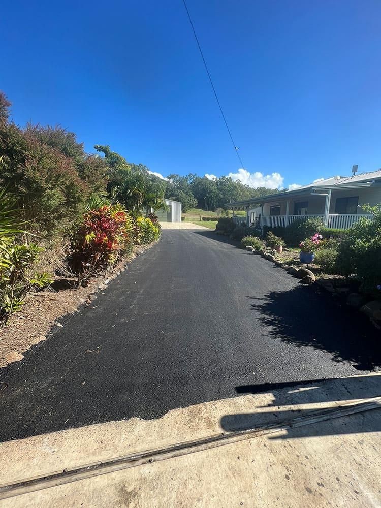 A Newly Paved Road Leading To A House On A Sunny Day — Elite Bitumen & Asphalt In Mackay, QLD