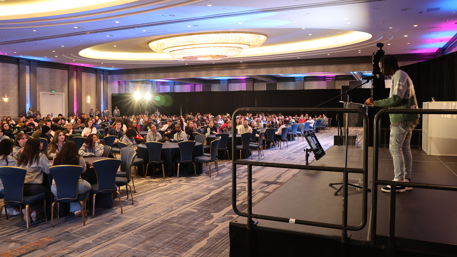 Crowd listening to a keynote speaker on stage