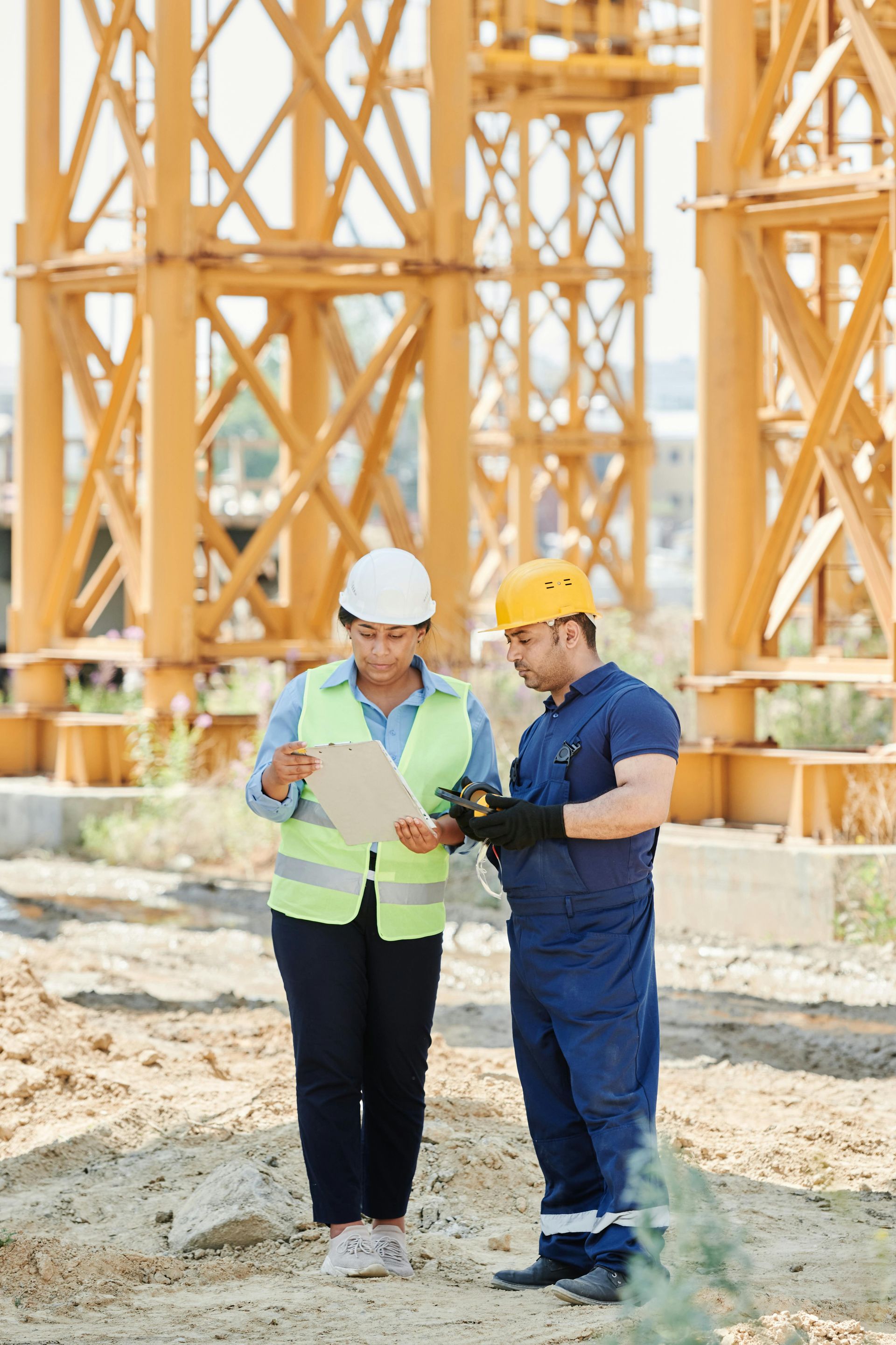 Construction workers examining blueprints at a construction site.