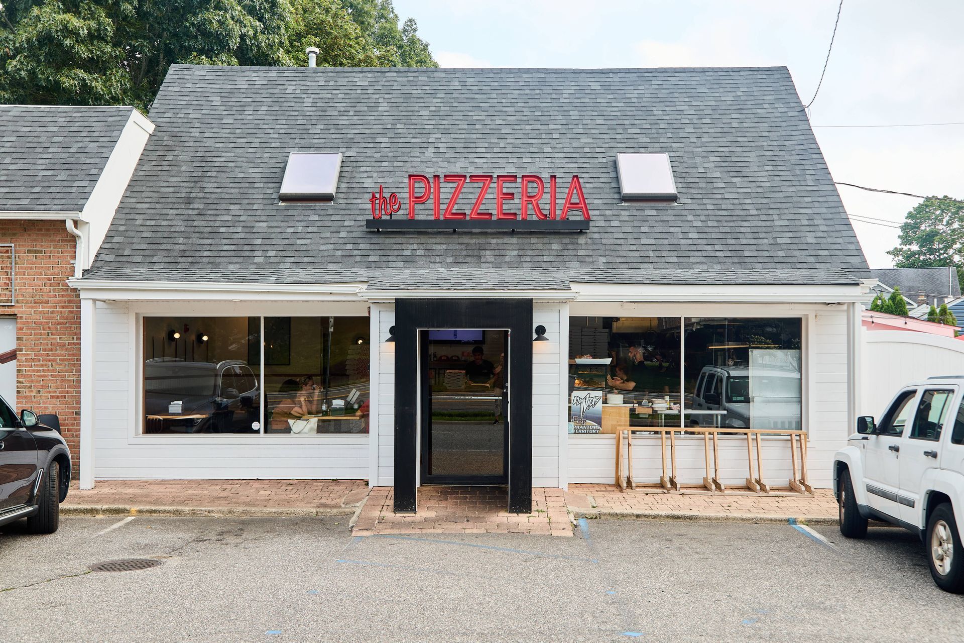 A variety of pizzas are displayed in a glass case in a restaurant.