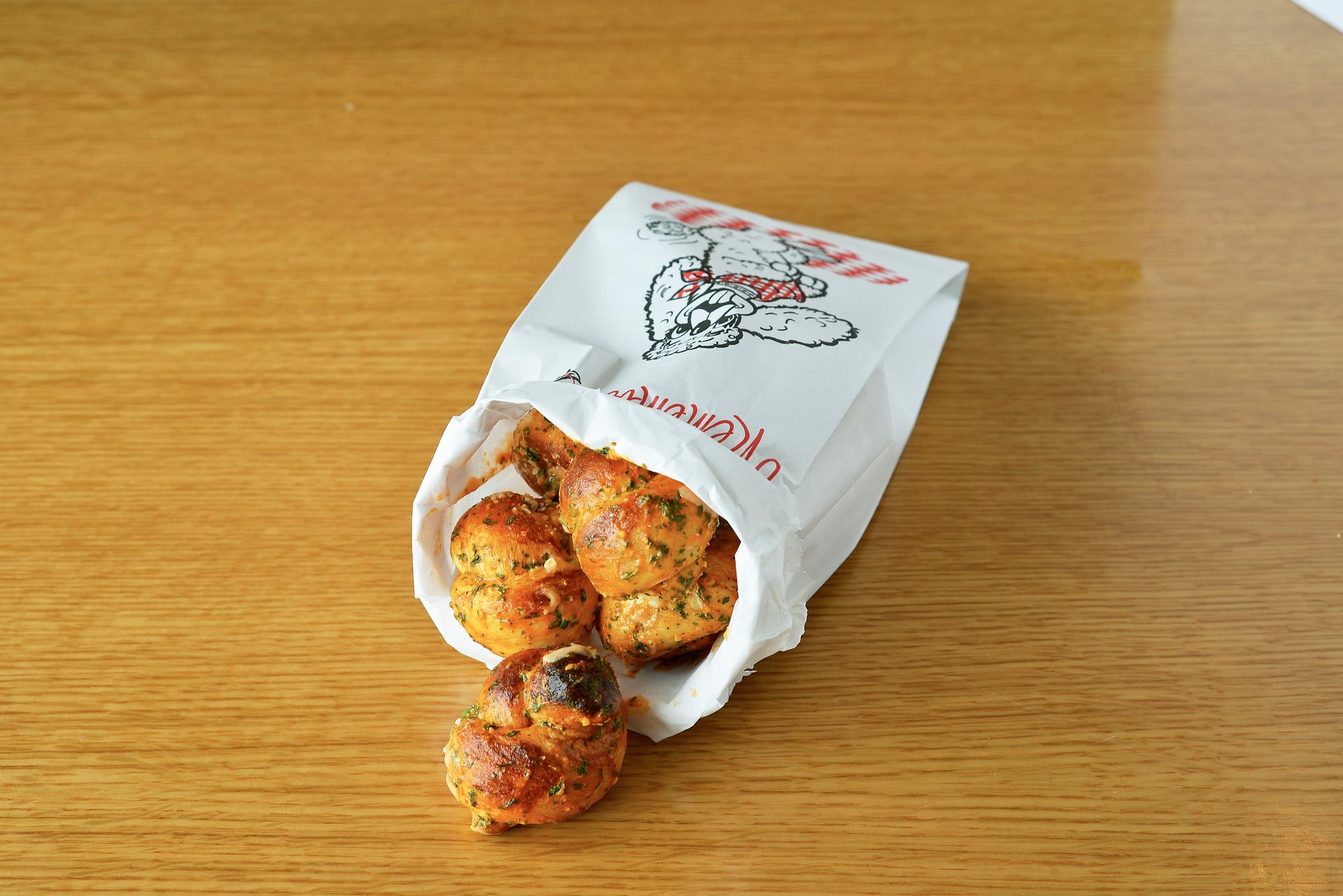 A bag of food is sitting on a wooden table.