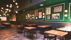 A restaurant with tables and chairs and a bar.